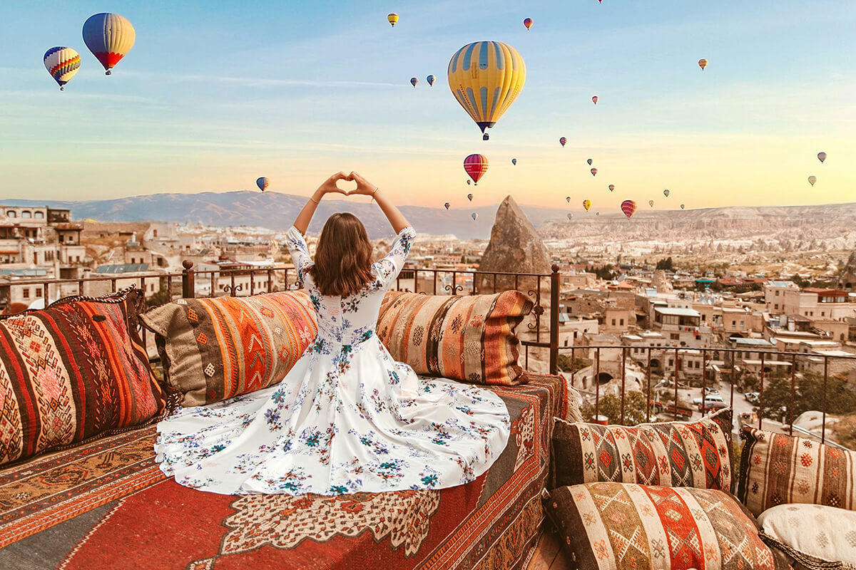 Du khách mặc trang phục sáng màu chụp ảnh khinh khí cầu Cappadocia